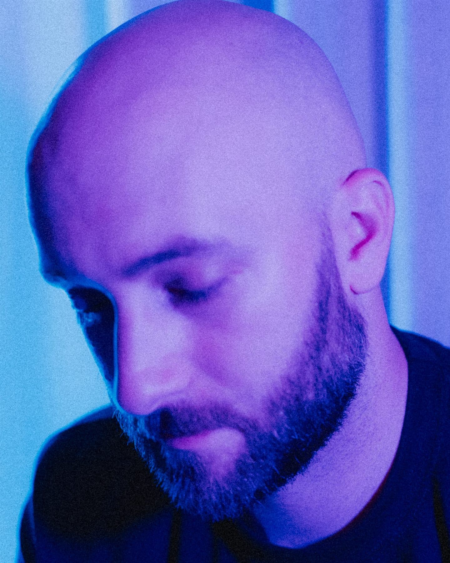 Broey artist portrait lit in blue and purple.
